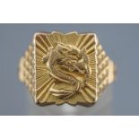 A yellow metal rectangular signet ring depicting a Chinese dragon.