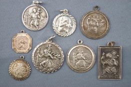 A collection of eight white metal St Christopher pendants. Most marked silver or 925.