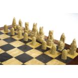 A cased resin replica of the British Museum Lewis chess set with another chess board