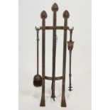 A wrought iron set of three fire irons on stand in Art Nouveau style,