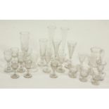A collection of old glasses including flutes, custard cups, etched tankard,