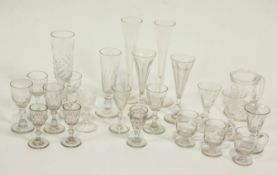 A collection of old glasses including flutes, custard cups, etched tankard,