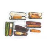 A collection of amber/meerschaum tobacco holders with silver or gold mounts, some cased,