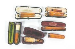 A collection of amber/meerschaum tobacco holders with silver or gold mounts, some cased,