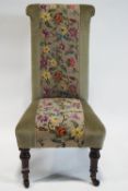 A 19th century Prie Dieu with central panel of floral embroidery raised on turned mahogany legs,