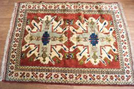 A Turkish caucasian rug with two central medallions on a pink field,