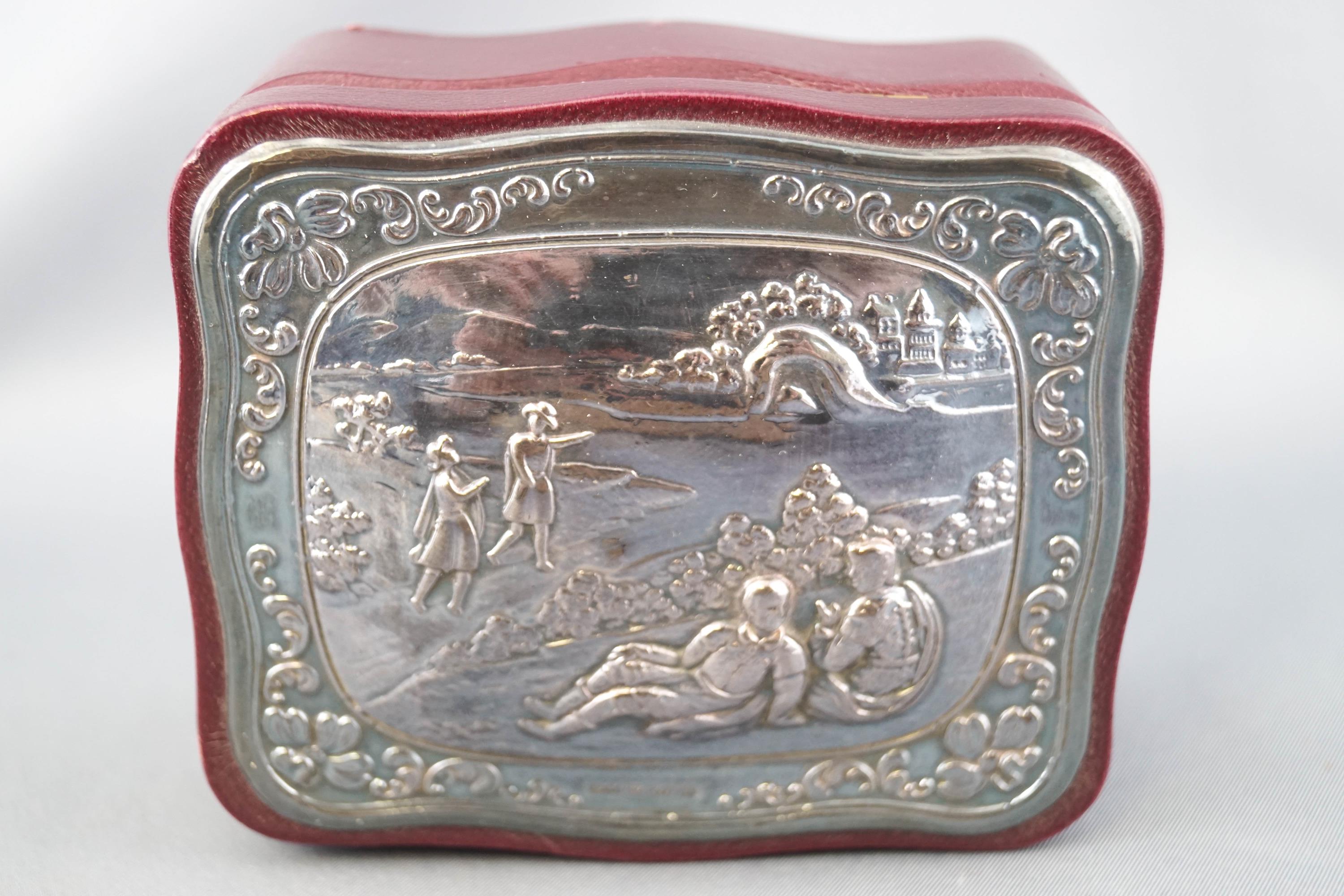 A leather covered shaped small jewel box with an applied silver lid,