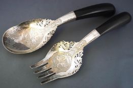 A pair of possibly Malaysian white metal and horn salad servers with pierced decoration,