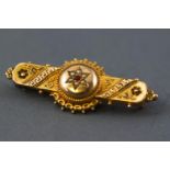 A yellow metal filigree design hollow bar brooch having a central cluster set with paste stone and