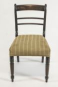 Four late Regency mahogany dining chairs with plain rail backs on stuff over seats raised on