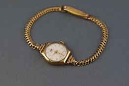 A yellow metal wristwatch having a circular white dial, signed Marvin.