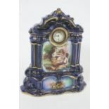 An Edwardian blue and gilt earthenware mantel clock, decorated with figures,