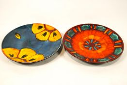 Two brightly decorated Poole pottery chargers,