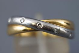 A yellow and white metal crossover ring.