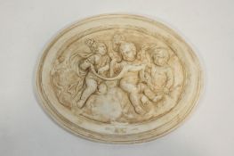 A moulded composite wall plaque, decorated with putti,