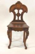 A Victorian oak hall chair, the pierced and lobed back above a solid seat on carved cabriole legs,