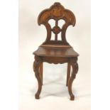 A Victorian oak hall chair, the pierced and lobed back above a solid seat on carved cabriole legs,