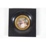 An 18th century French style round miniature of a couple in an interior, in a blackened frame, 4.