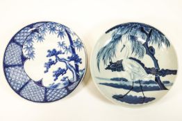 Two Chinese porcelain blue and white chargers, one with a heron in a landscape,