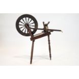 A late 19th century spinning wheel, on three turned tapering legs,
