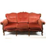 A French Rococo style mahogany framed three piece salon suite, comprising a three seater sofa,