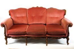 A French Rococo style mahogany framed three piece salon suite, comprising a three seater sofa,