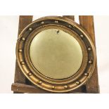 A Regency style gilt framed convex circular mirror, the frame embellished with ball finials,