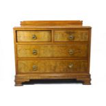 An Edwardian walnut chest of two short and two long drawers with brass ring handles and ogee