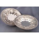 A pair of silver low form fruit bowls, raised on trumpet feet,