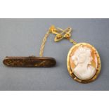 A collection of two brooches to include a filigree bar brooch with pin and safety chain,