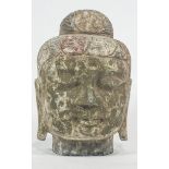 A carved stone head of Buddha, traces of polychrome decoration,