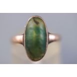 A yellow metal ring set with an oval cabochon nephrite jade measuring approximately 15.3mm x 7.7mm.