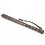 A lignum vitae truncheon with turned grip and leather strap handle,