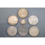 A collection of seven coins to include: Crowns, Peso's and a shilling. Dating from 1819 to 1935.