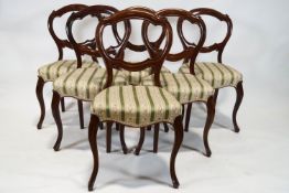 A set of six Victorian mahogany balloon back chairs with stuff over seats on cabriole legs,