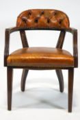 A mahogany office chair with curved leather button back,