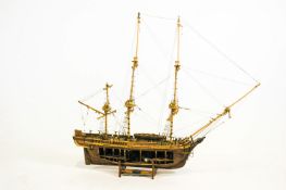 A cut-away wood scale model of HMS Bounty on stand,