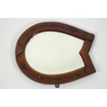 An Edwardian mahogany framed wall mirror the frame in the form of a horseshoe,