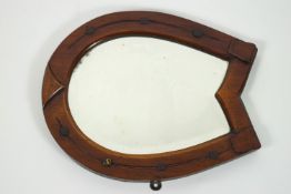 An Edwardian mahogany framed wall mirror the frame in the form of a horseshoe,