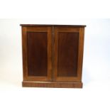 A Victorian mahogany two door cupboard, the twin panelled doors above plinth base,