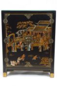 A Chinoisere two door cabinet decorated with figures in landscapes on a black ground,