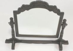 An oak framed dressing table mirror, the arched mirror with scrolled cresting rail,