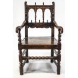 A 17th century oak elbow chair, with open arched back, acorn finials,