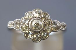 A white metal daisy cluster ring set with fifteen old European cut diamonds measuring from 2.