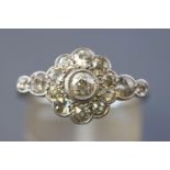 A white metal daisy cluster ring set with fifteen old European cut diamonds measuring from 2.