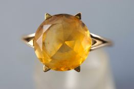 A yellow metal single stone ring set with a circular faceted cut citrine quartz measuring