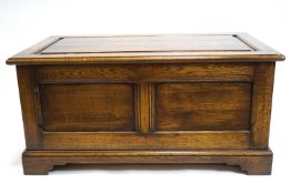 A period style plain oak panelled blanket box on a bracket foot base,