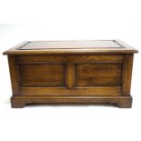 A period style plain oak panelled blanket box on a bracket foot base,