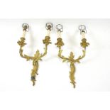 A pair of gilt wall brackets, of two-branch Rococo scroll foliate design, with two sconces,