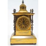 A Victorian brass columned clock with pierced pagaoda style top over a rose window Arabic dial,
